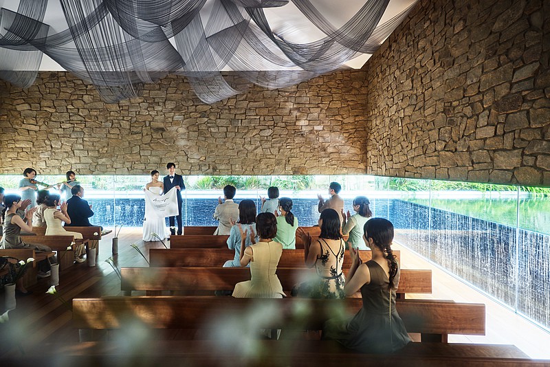 滝の水しぶきが陽光を受けて煌めき、花嫁の美しさを際立たせる